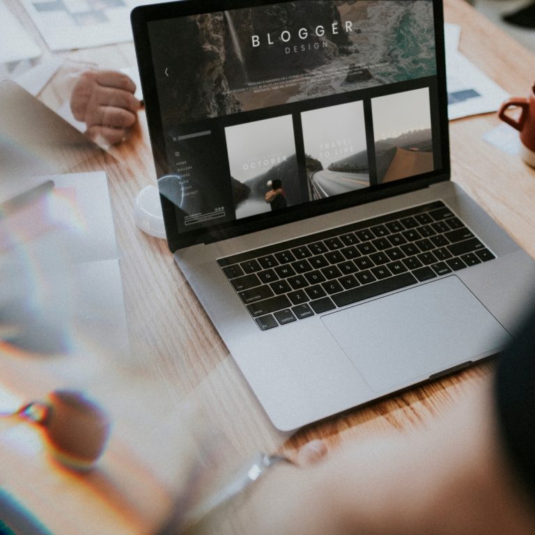 a group of people sitting around a table looking at a laptop and brainstorming a blog about seo for writers