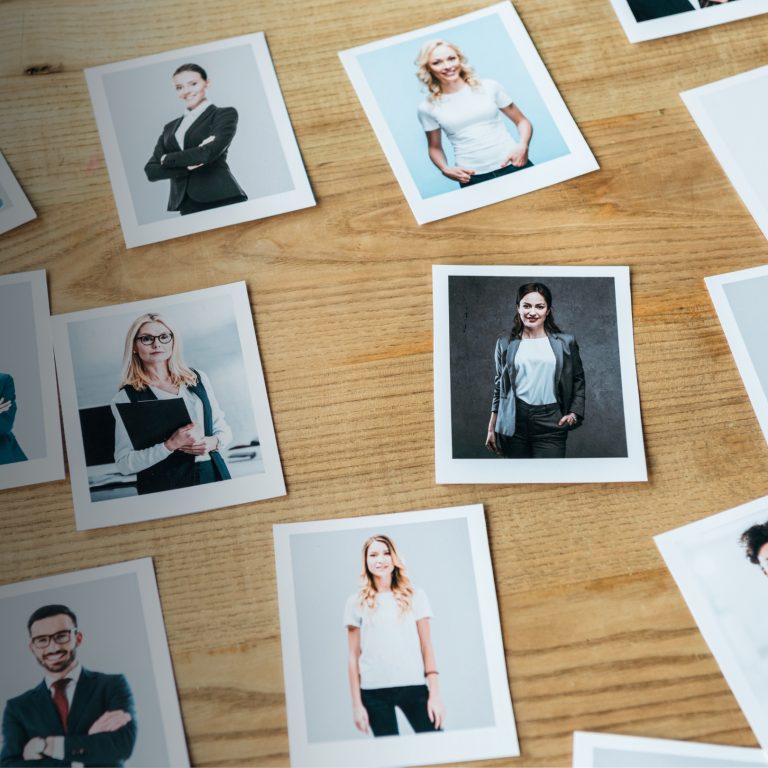 a wooden mood board with a variety of professional portraits of people to represent establishing a branding narrative